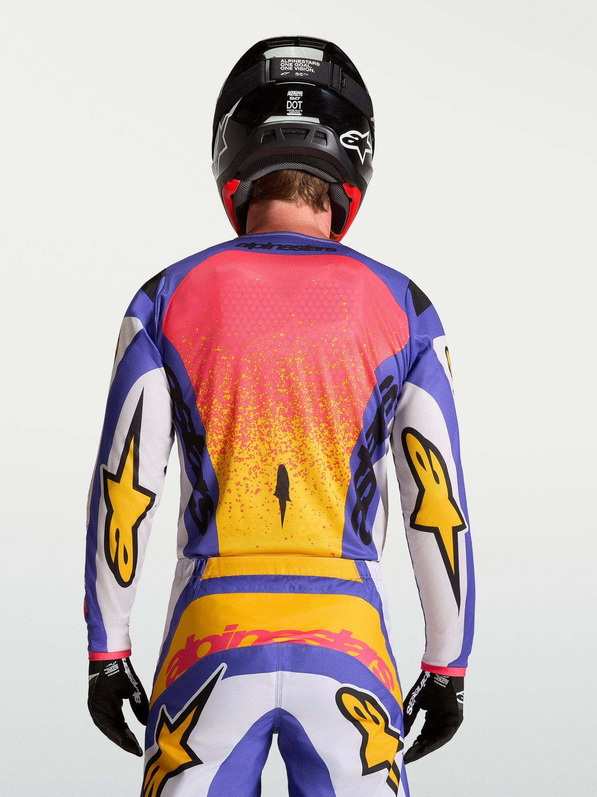 Alpinestars Fluid Drag Jersey, motocross gear for men in Light Lilac and Blue Iris with gold accents, back view on-model with matching pants and helmet.