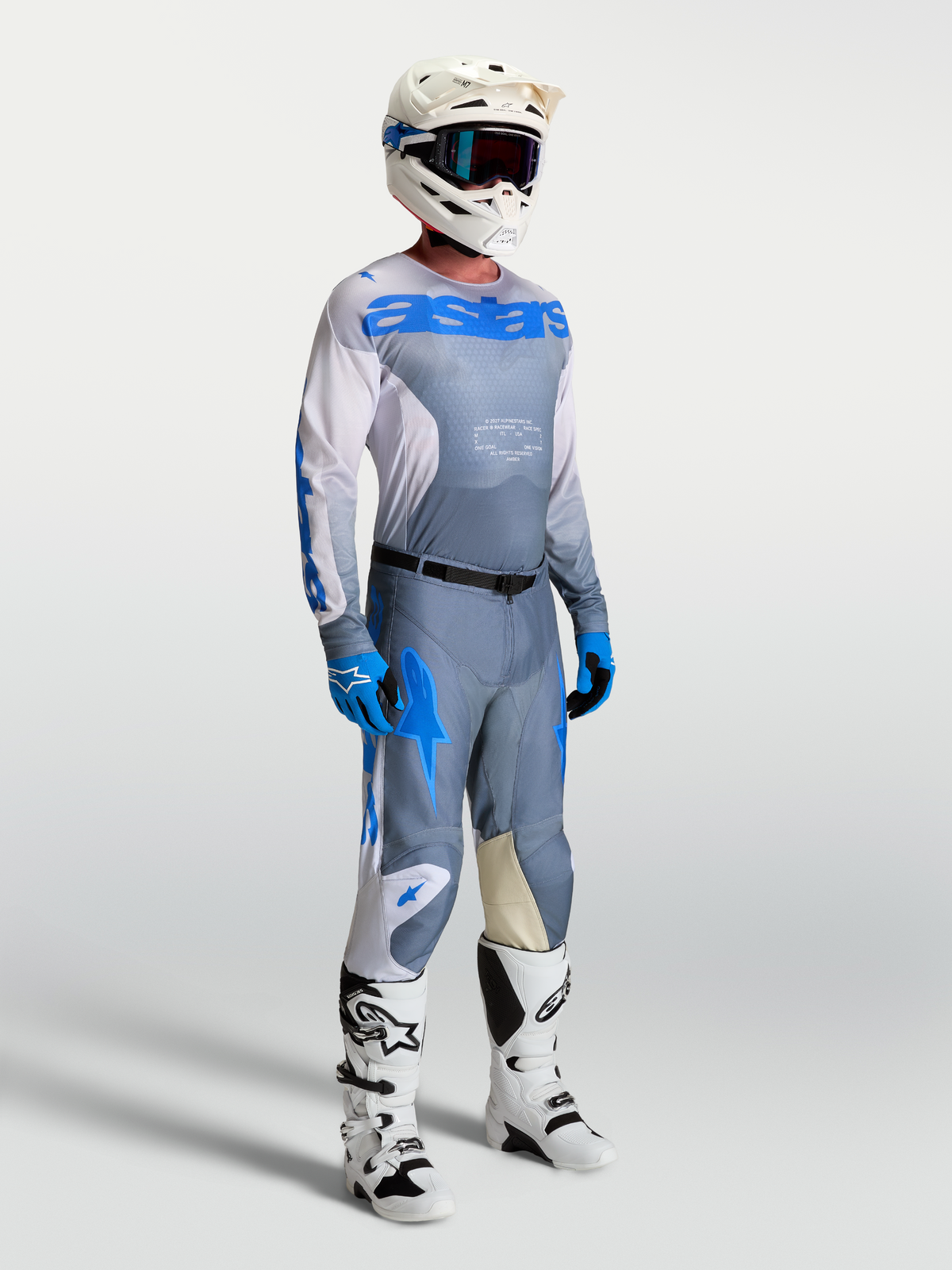 Alpinestars Racer Amber tröja, grå och blå motocrossutrustning för herr på modell med hjälm och stövlar.