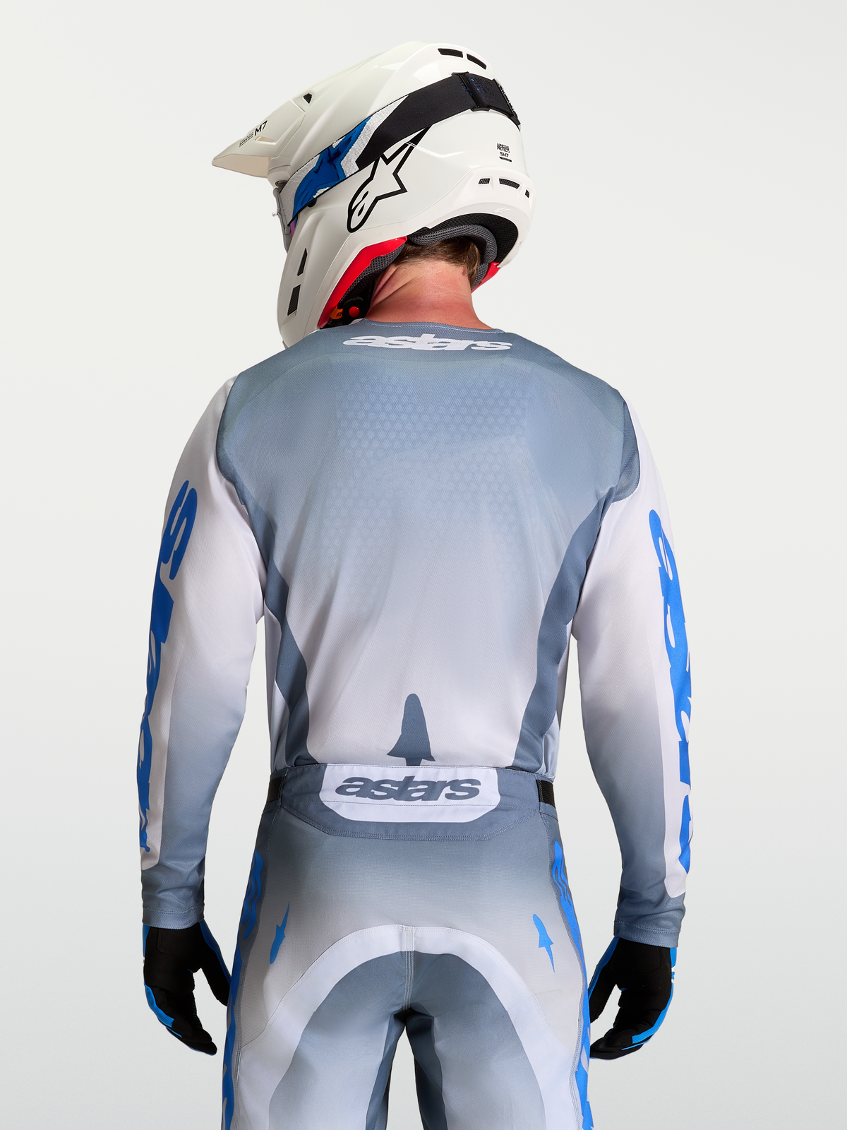 Alpinestars Racer Amber tröja, grå och vit motocross-tröja buren av modell bakifrån med vit hjälm