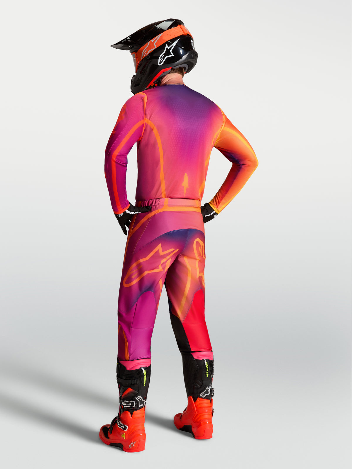 Alpinestars Fluid Kepler Jersey, purple and orange performance motocross gear shown from the back on a rider.