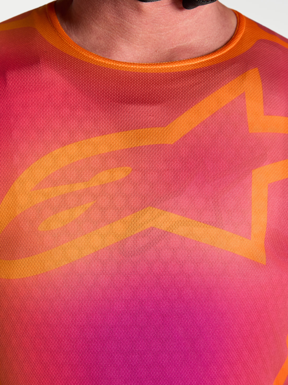 Alpinestars Fluid Kepler Motocross Jersey, close-up of purple and orange chest design with iconic orange A-star logo.