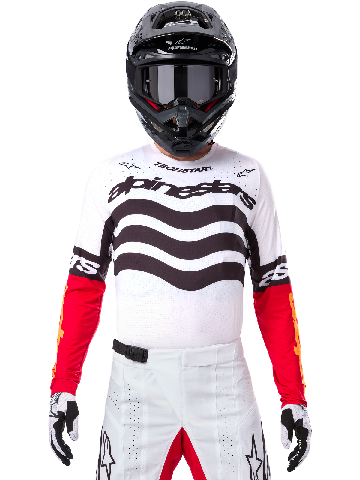 Motocrossförare i komplett racingutrustning, Limited Edition Techstar Deep-tröja i vitt och svart med röda ärmar, med vågig grafik och tydlig Alpinestars-branding, vita motocrossbyxor, svart hjälm och goggles, matchande outfit för terrängkörning