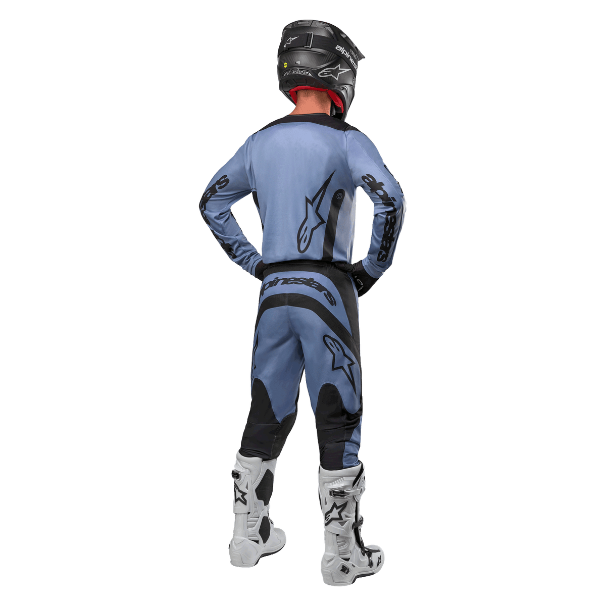 Motocrossförare sedd bakifrån iklädd Alpinestars 2024 Fluid Lurv-tröja och matchande byxor i ljusblått och svart, med svart logotyp på ryggen och ärmarna, svart hjälm och vita stövlar.