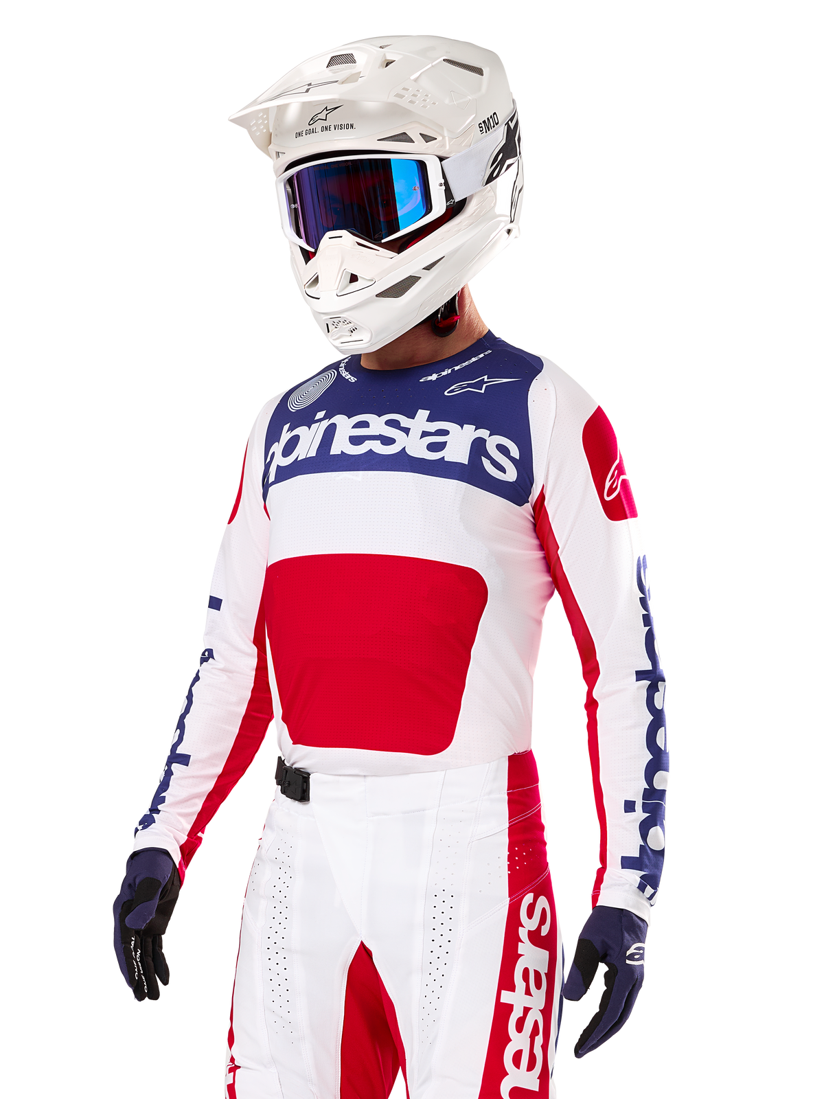 Motocrossförare klädd i Alpinestars Limited Edition Techstar Fortitude-tröja, klarröd, vit och blå, med vit hjälm, blå goggles och matchande byxor, högpresterande racingkläder för terrängkörning