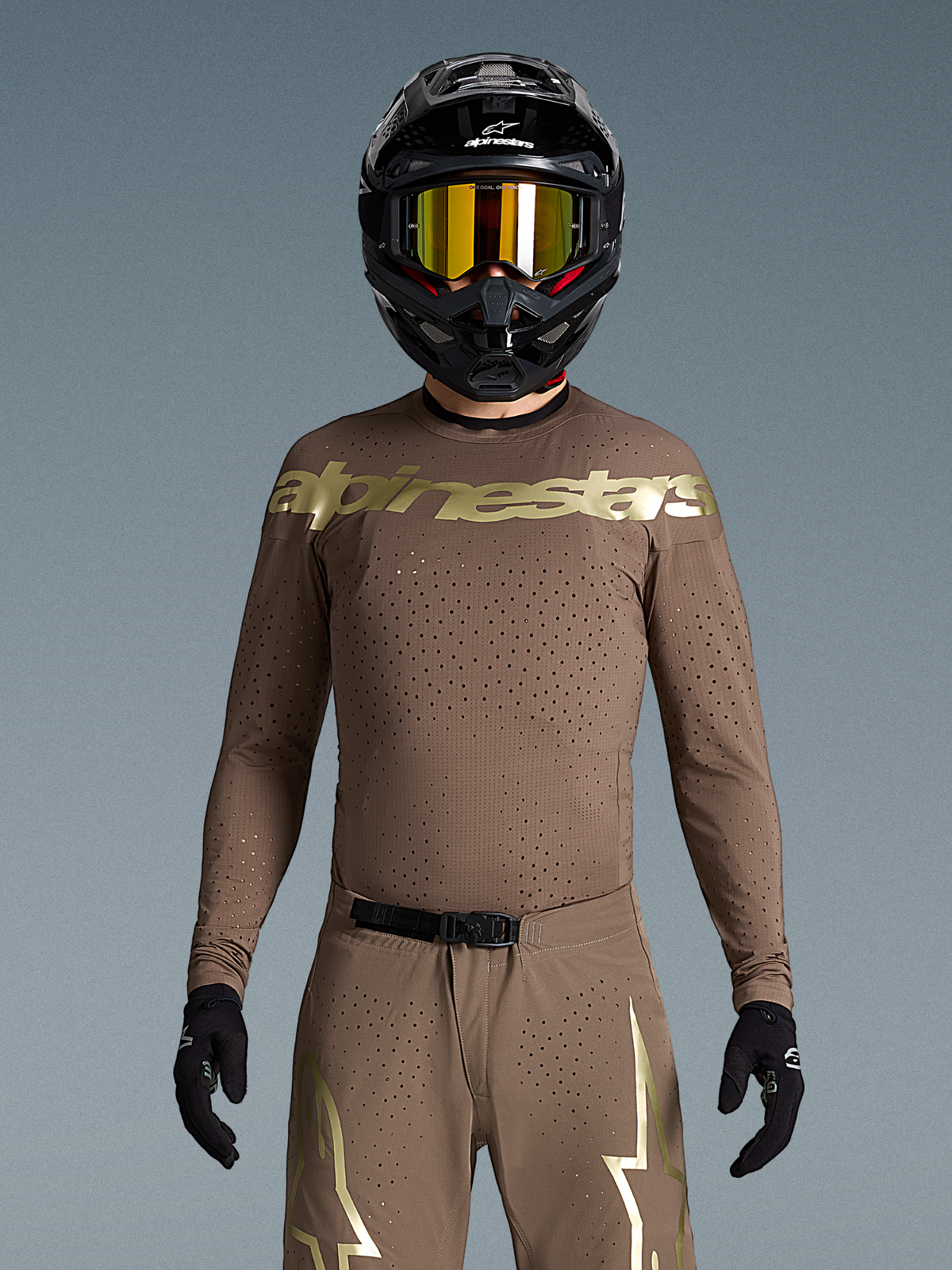 Alpinestars Begränsad Upplaga Supertech Air Gold tröja, motocrosströja för herr, brun och guld, laserutskuren ventilation, bärs av modell med matchande utrustning.