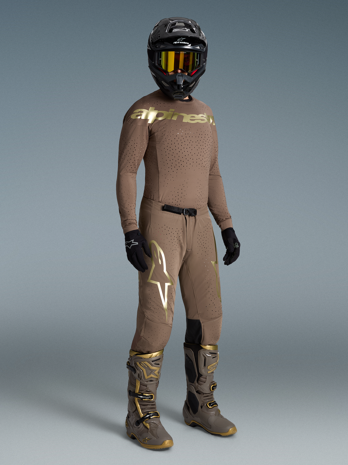 Alpinestars Begränsad Upplaga Supertech Air Set Gold, jordbrun motocrossutrustning för herr med ventilerad mesh i guld.