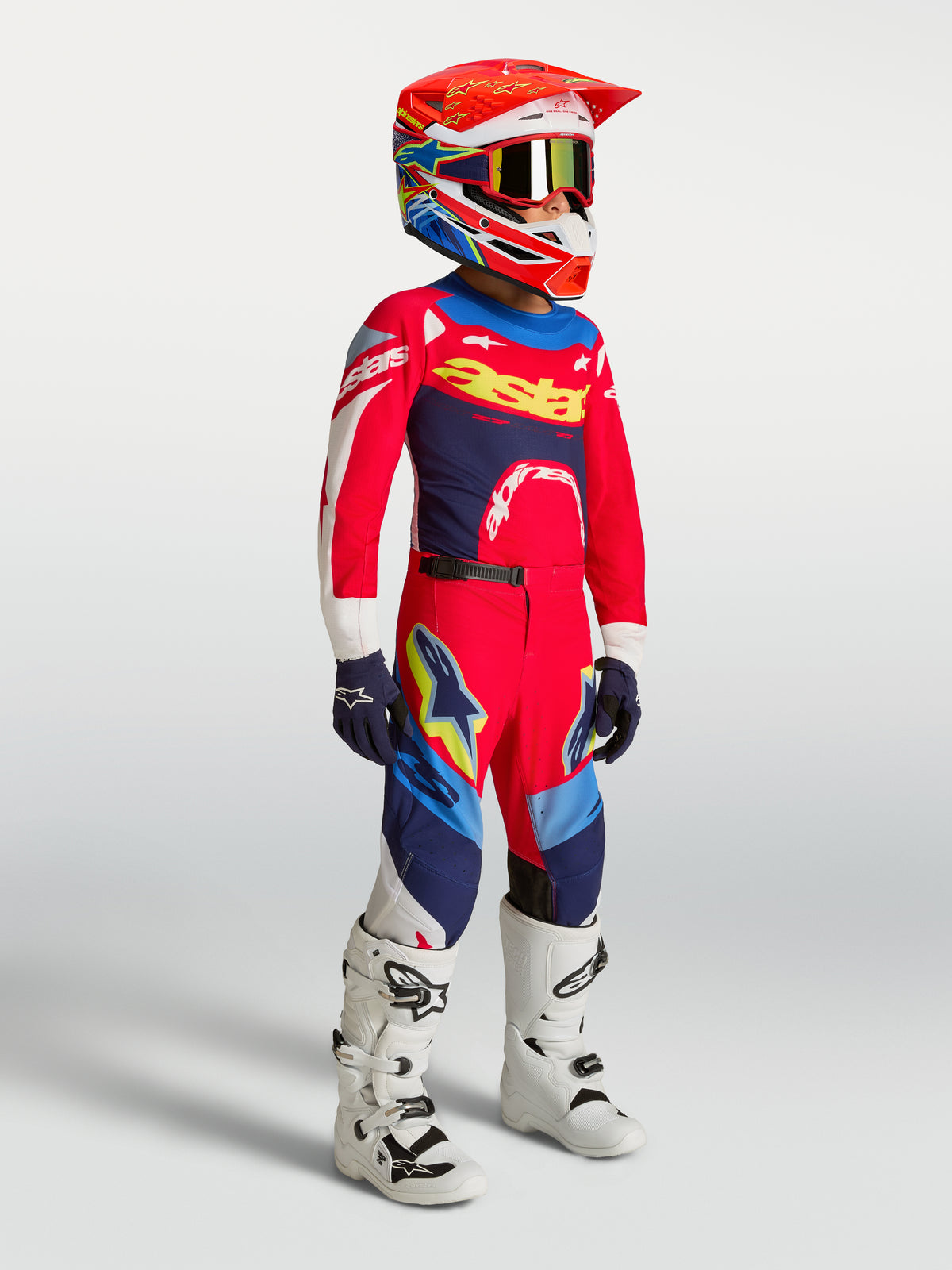 Alpinestars 2027 Ungdom Supertech Dyna tröja och gear set, röd och marinblå motocrossutrustning med vita motorcykelstövlar.