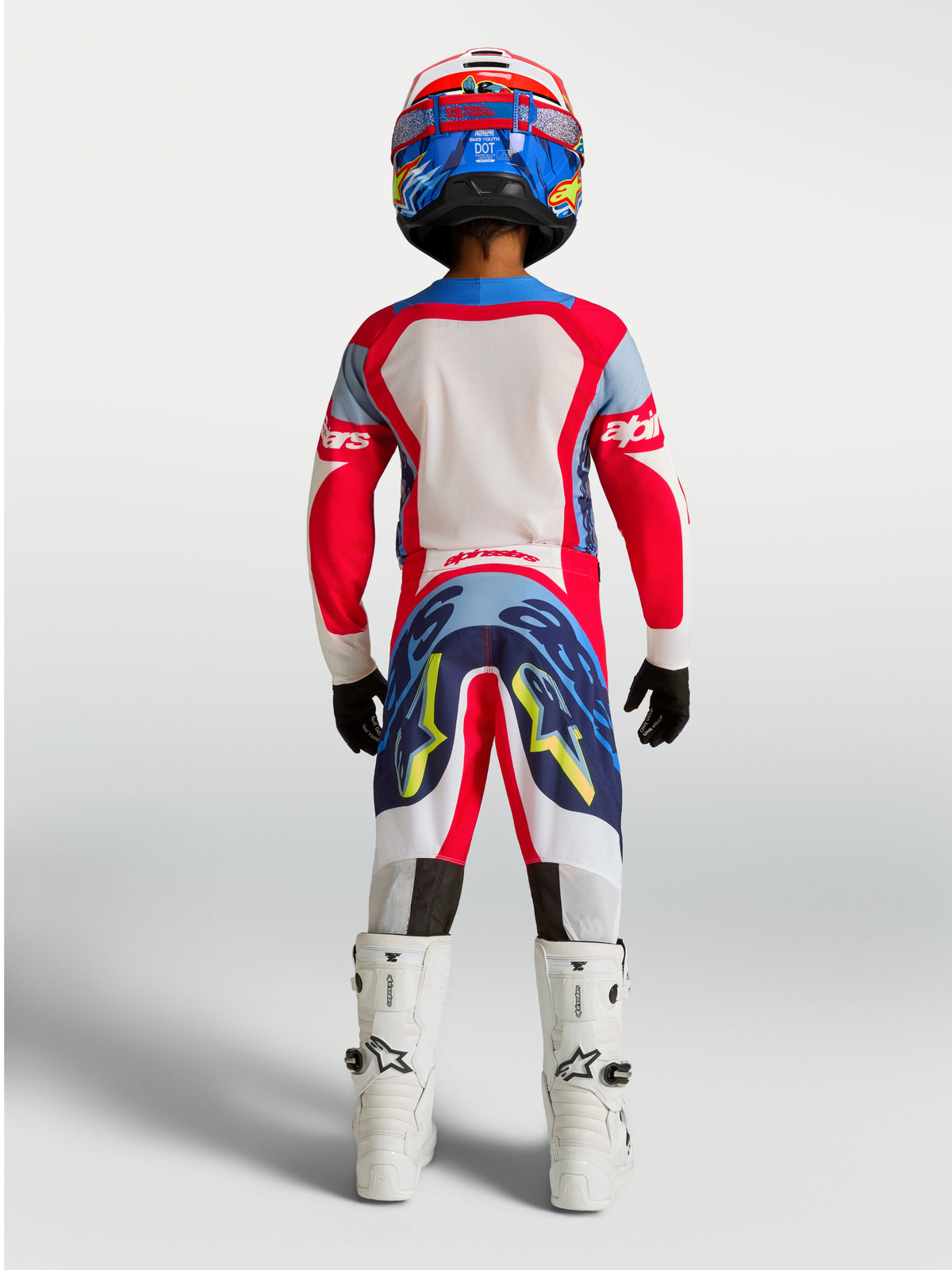 Alpinestars ungdom Supertech Dyna tröja och Gear Set, rött och marinblått motocrosställ, vy bakifrån på en ung förare.