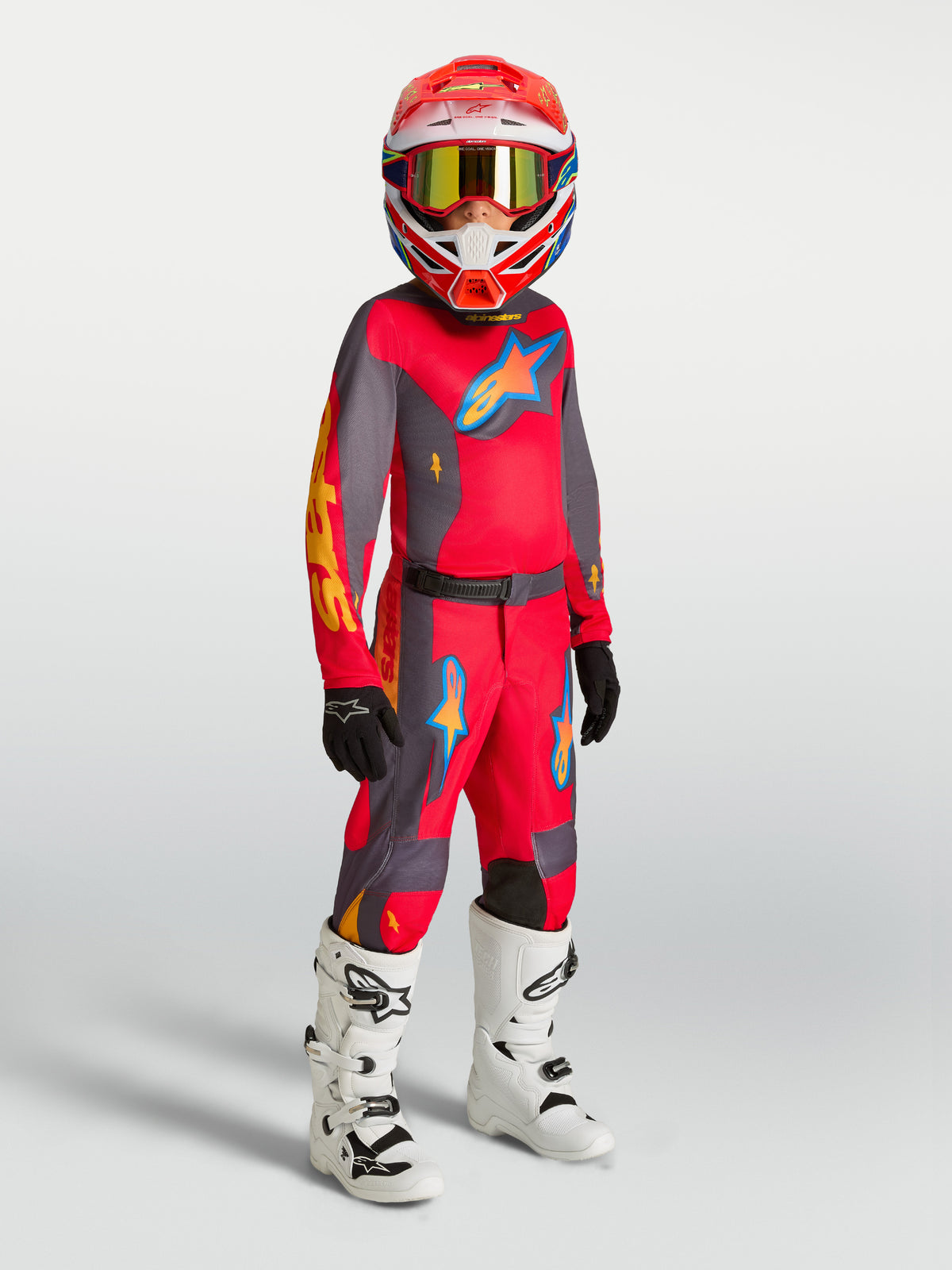 Alpinestars Fluid Hunt tröja och MX-ställ för ungdomar, röd och grå motocrossutrustning med vita stövlar.