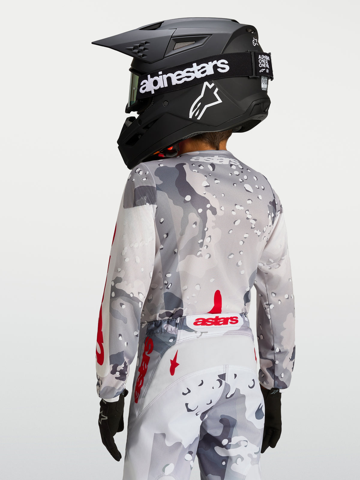 Alpinestars 2027 Ungdom Fluid Lone tröja, grå och röd motocrosströja, vy bakifrån med ergonomisk passform och förlängt bakstycke.
