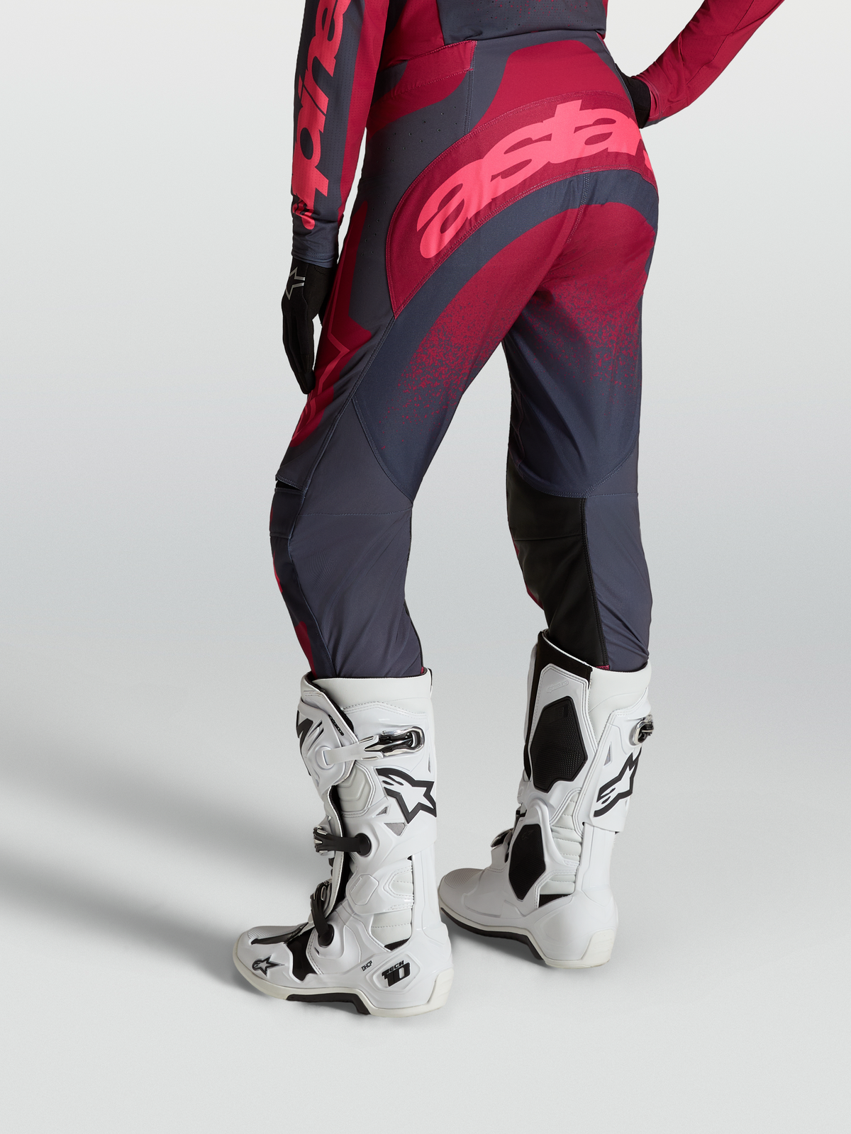 Alpinestars Stella Techstar Swan byxor, motocrossbyxor för dam bakifrån, röda och grå, vita Tech 10 motorcykelstövlar.