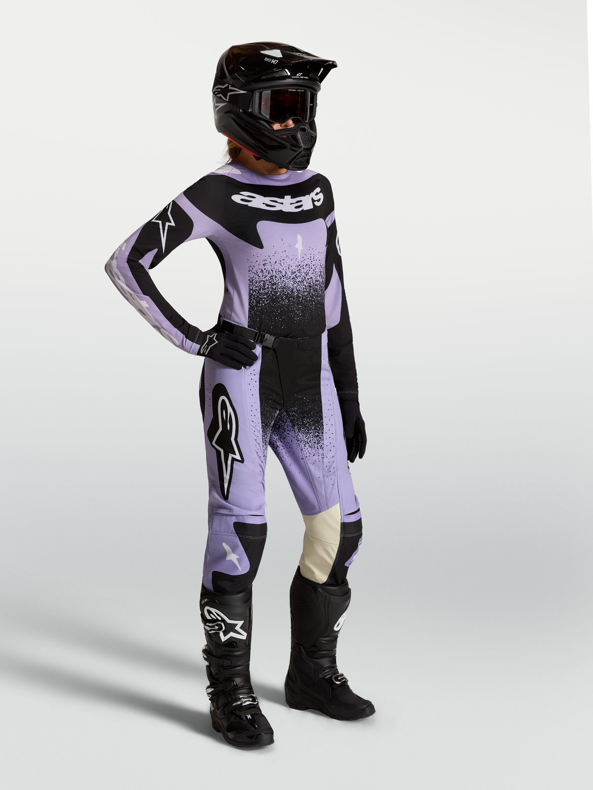 Alpinestars Stella Techstar Swan gear set, dam-motocrossutrustning i ljuslila och svart med swan-grafik, matchande tröja, byxor, svarta stövlar och hjälm.