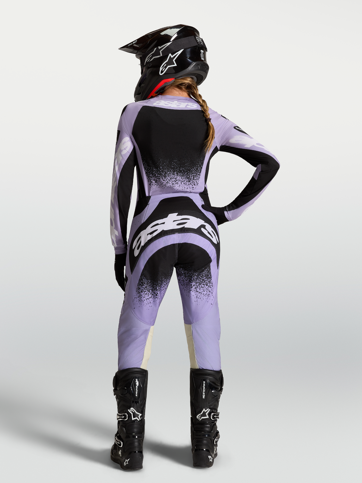 Alpinestars Stella Techstar Swan utrustningsset, motocrossutrustning för dam, ljuslila och svart, vy bakifrån på modell med matchande hjälm och stövlar