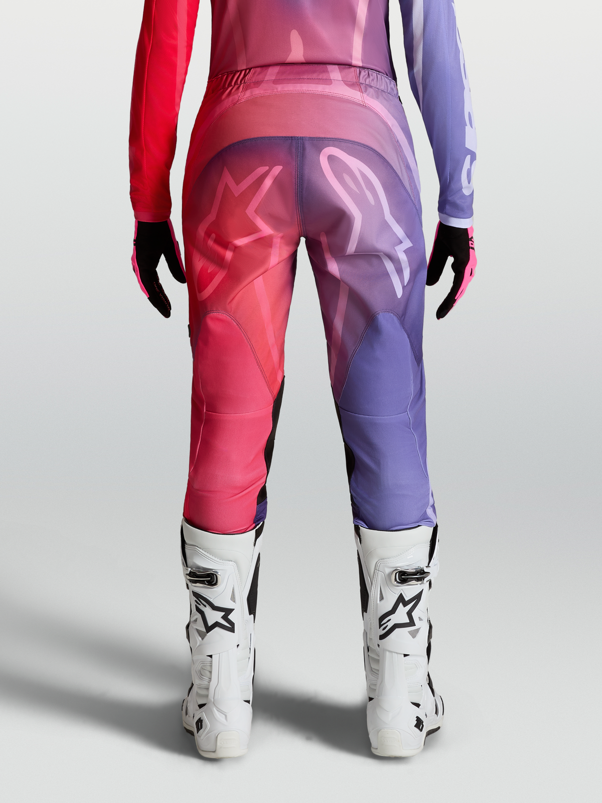 Alpinestars Stella Fluid Kepler byxor, dam-motocrossbyxor, lila och röda, vy bakifrån med förböjda ben och ergonomisk passform