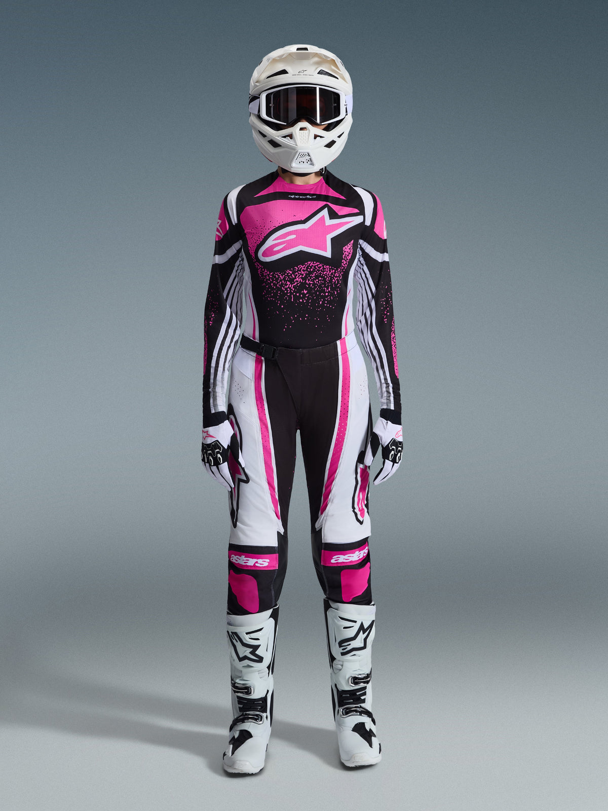 Alpinestars 2026 Stella Techstar Nomur utrustningsset för damer, komplett racingoutfit för motocross i svart, vitt och fuchsia, tröja med en stor stjärnlogotyp och rosa stänkdesign, matchande byxor, vit hjälm med goggles, svarta och vita stövlar, koordinerad offroad-utrustning för damer