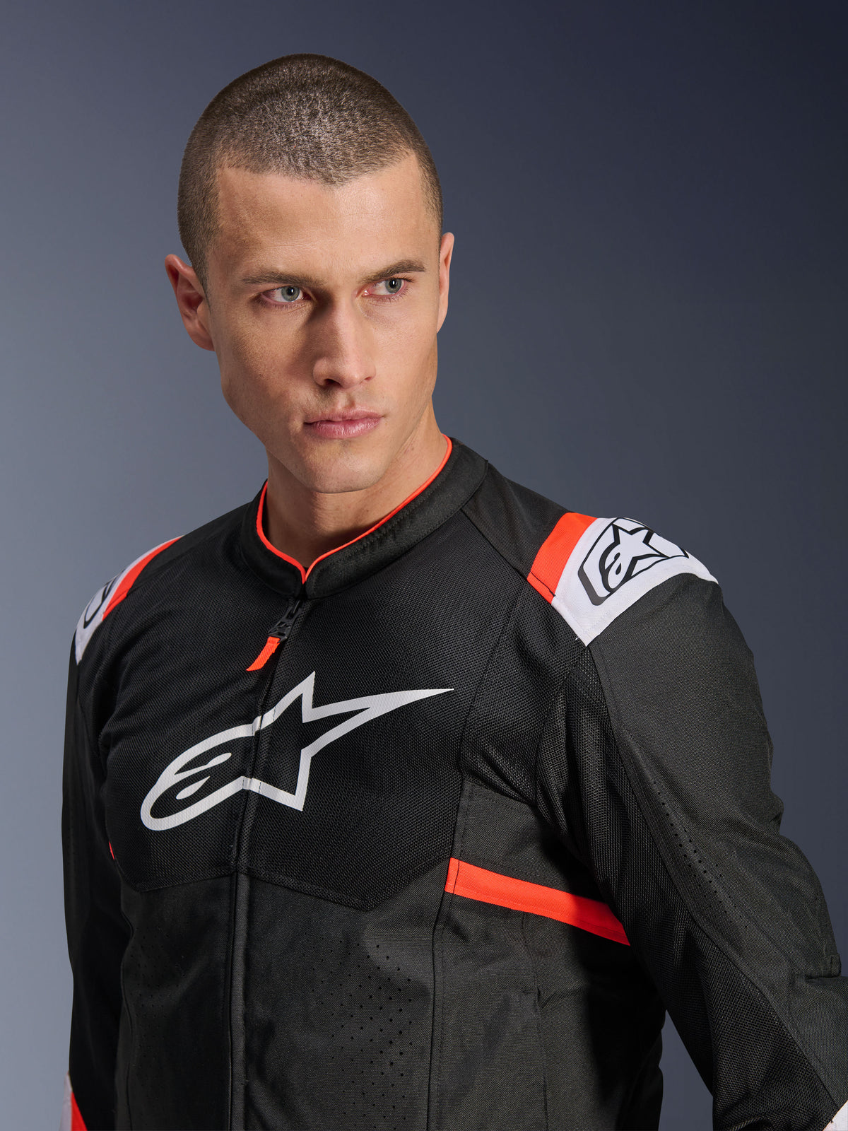 Alpinestars T-SPS Air v2 Jacket, Black with White and Red Fluo accents, mesh textile construction for airflow, large white Alpinestars logo on chest, worn by model, urban sport riding style