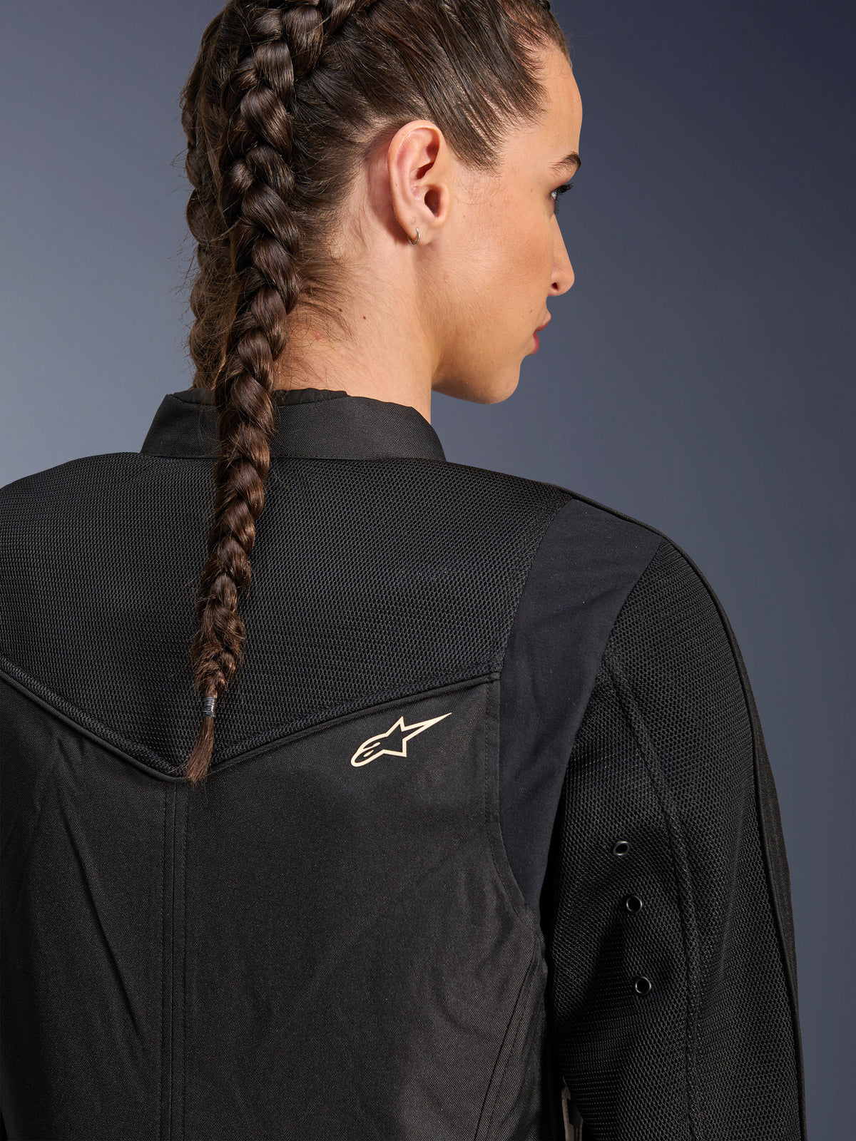 Alpinestars Stella T-Dyno Air Jacket, Women's Black Motorcycle Jacket, close-up back view showing 3D mesh panels on the yoke and upper back for airflow, featuring a small white star logo, worn by a model with braided hair.