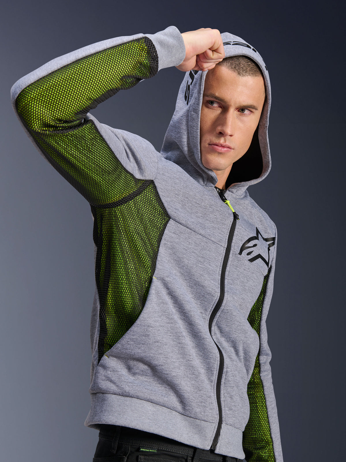 Alpinestars Chrome Air Sport Hoodie, gråmelerad och svart, med ljusgröna mesh-paneler för luftflöde på sidorna och under ärmarna, tekniskt fleece-material med huva, svart Alpinestars-logotyp på bröstet, urban motorcykelutrustning