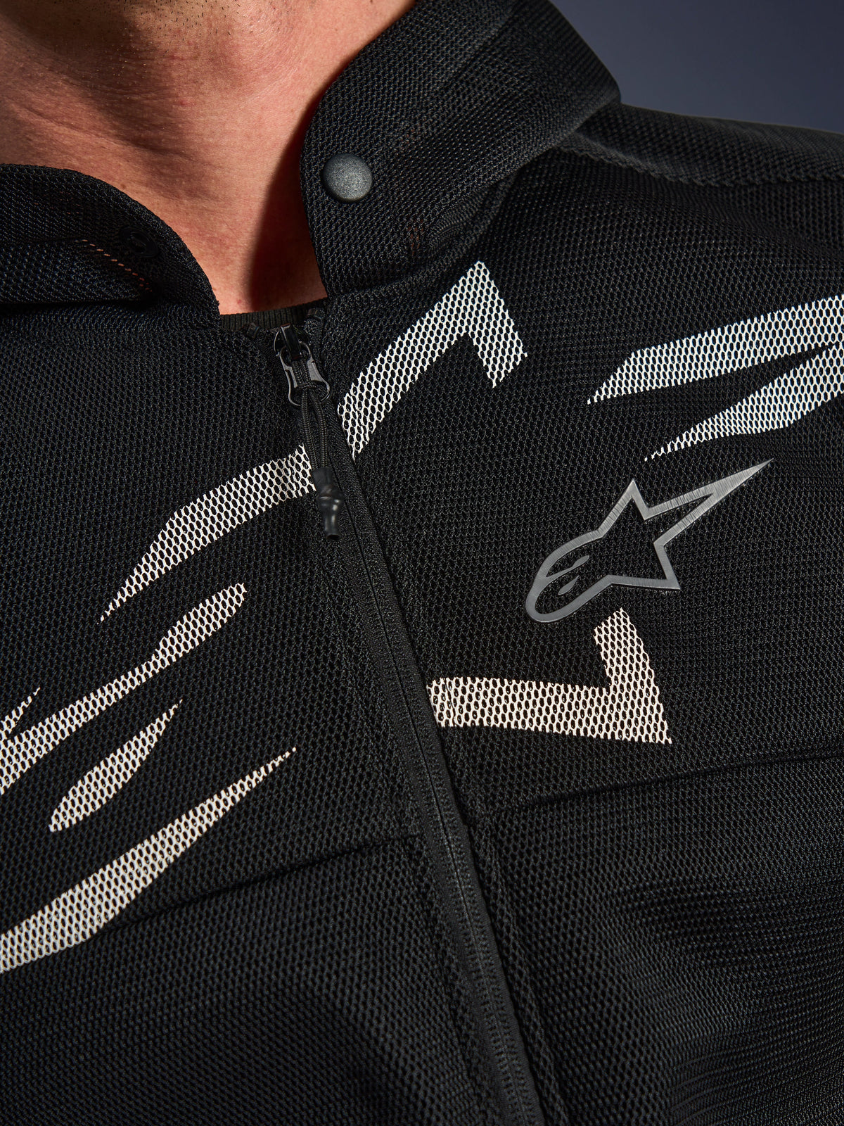 Alpinestars Chrome Superairflow Hoodie, motorcykelhoodie, svart med vit och grå grafik, närbild av bröstet som visar teknisk 3D-mesh-konstruktion, dragkedja framtill och krage med tryckknapp, med Alpinestars logotyp