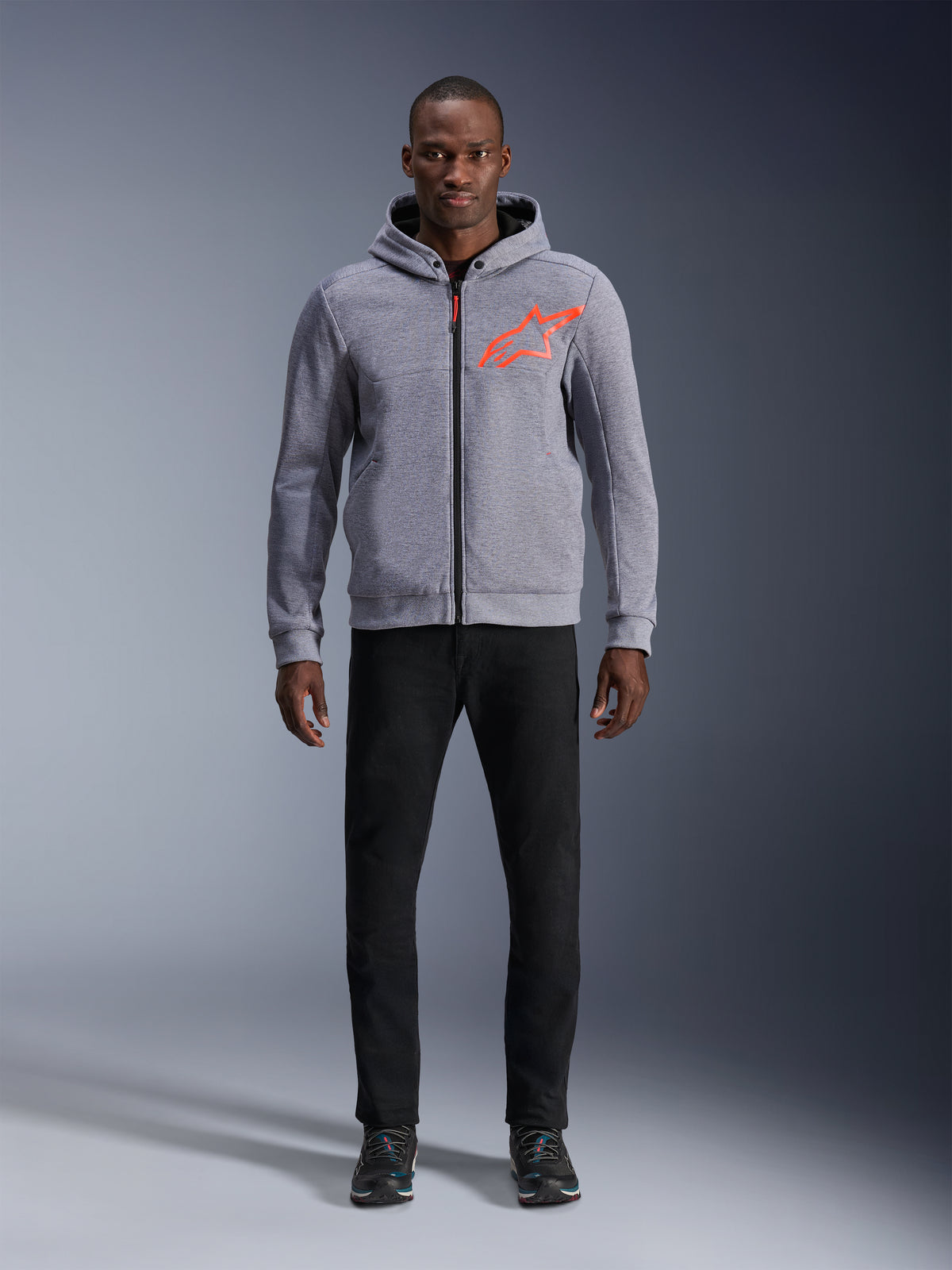 Alpinestars Chrome V2 Sport jacka med huva, grå och röd fluo urban motorcykeljacka för herr bärs av modell med svarta byxor.