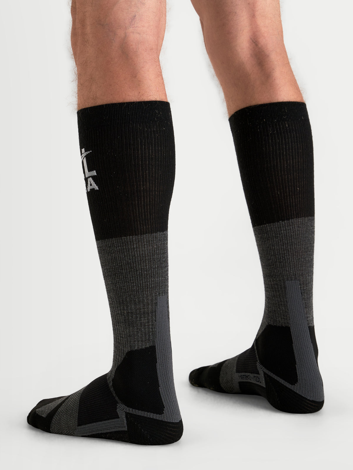 Alpinestars AT-8 Merino strumpor, äventyrsmotorcykelstrumpor, mörkgrå och svarta, termiska funktionsstrumpor med förstärkt dämpning, bärs på en modell