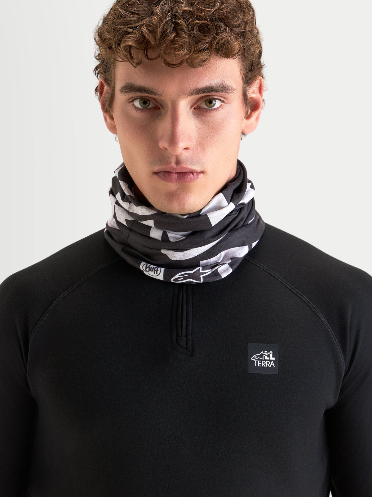 Alpinestars Buff All Terra Primaloft Neck Tube, cold-weather motorcycle neck warmer worn by a model, black and gray pattern, low-bulk textile construction with PrimaLoft insulation