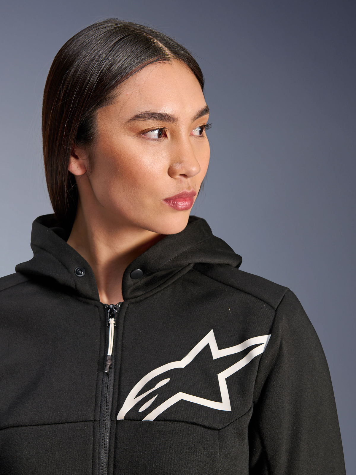 Alpinestars Stella Chrome V2 Sport Hoodie, svart med vit Astars-logotyp, motorcykelhoodie för damer, tekniskt fleecematerial, med dragkedja framtill och huva med tryckknapp i kragen, avslappnad urban körutrustning