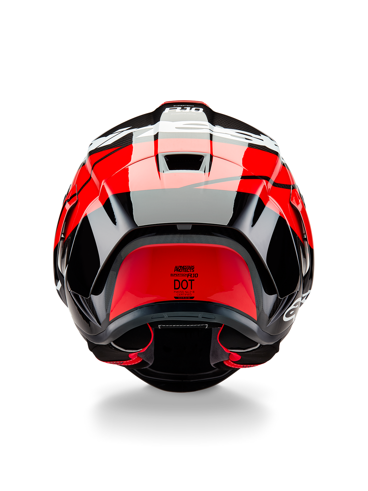 Alpinestars Supertech R10 Element-hjälm, sedd bakifrån, svart kolfiber med högblanka klarröda och vita detaljer, utrustad med aerodynamisk bakspoiler, ventilationsöppningar och DOT-certifieringsetikett, strömlinjeformad racinginspirerad design med kolfiberdetaljer
