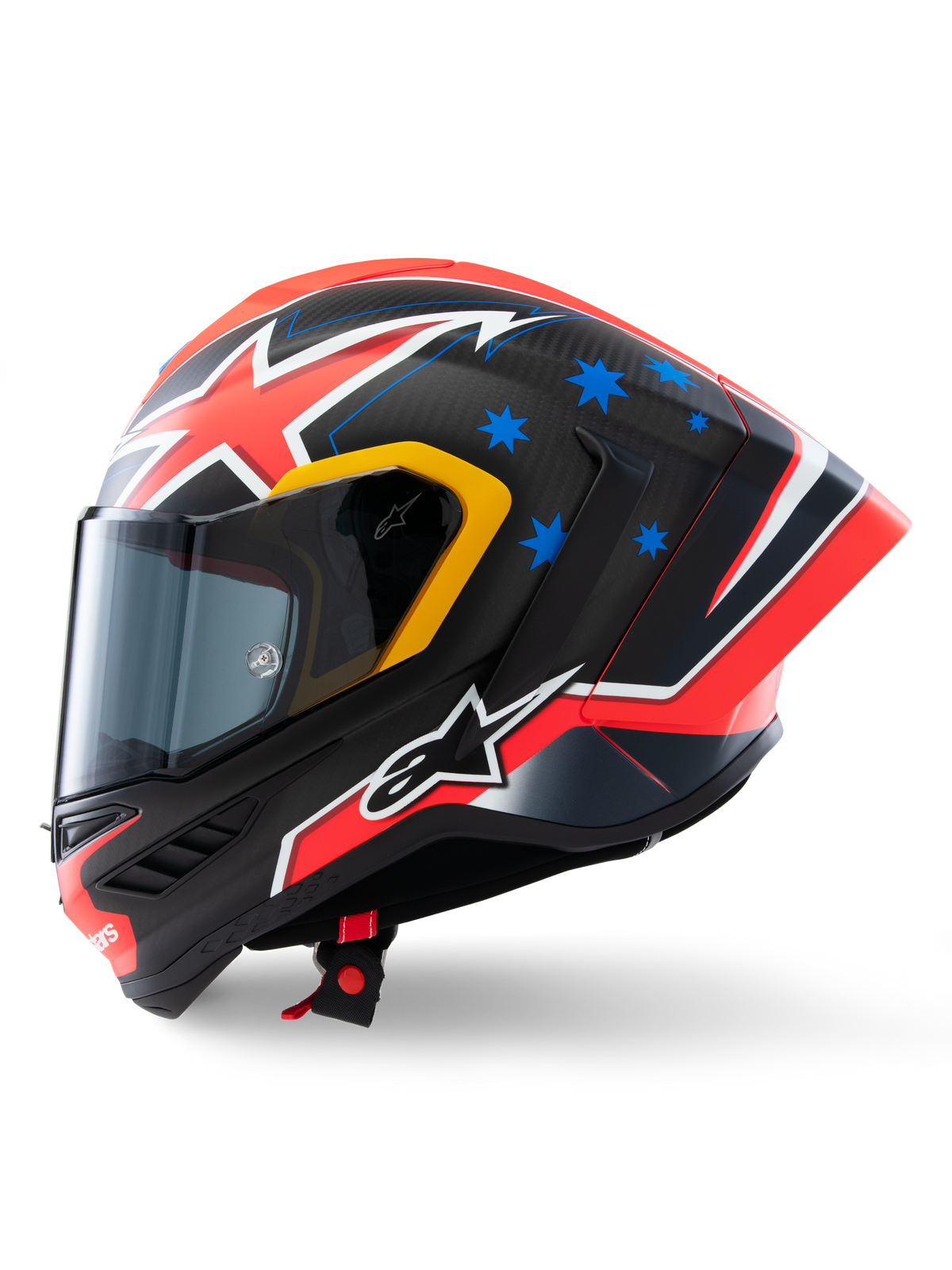 Alpinestars Supertech R10 Miller Limited Edition-hjälm, sidoprofil, Carbon Red Matt-finish med synlig kolfiberväv, röd och vit blixtgrafik, blå stjärnor på baksidan, gula accenter runt visiret och vit Alpinestars-logotyp, högpresterande racinghjälm för motorcykel