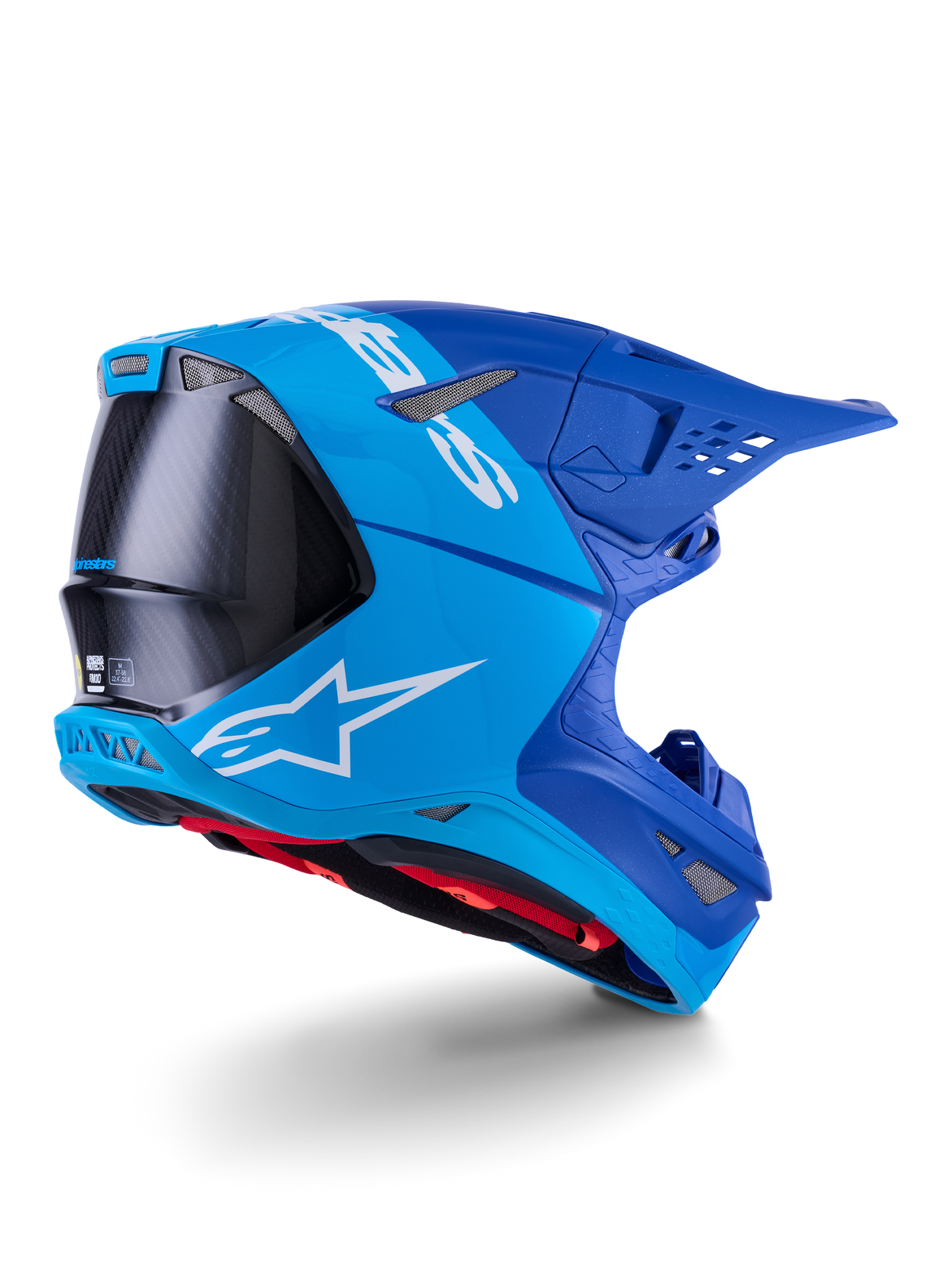 Alpinestars Supertech M10 Flood Helmet, Motocross Helmet, Bright Blue and Navy Blue with exposed Black Carbon fiber, rear-side profile showing ventilation ports and white logo, red interior lining, advanced aerodynamic design for off-road performance