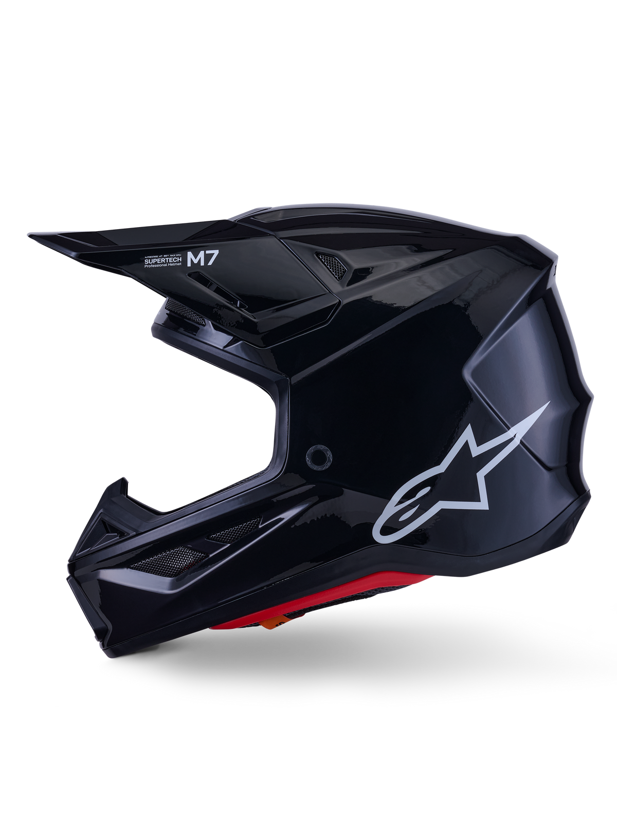 Alpinestars S-M7 Solid hjälm, blanksvart motocrosshjälm, sidoprofil som visar vit Alpinestars-logotyp, aerodynamiskt skal med ventilationsnät och röd invändig vaddering, avancerat skydd för terrängkörning