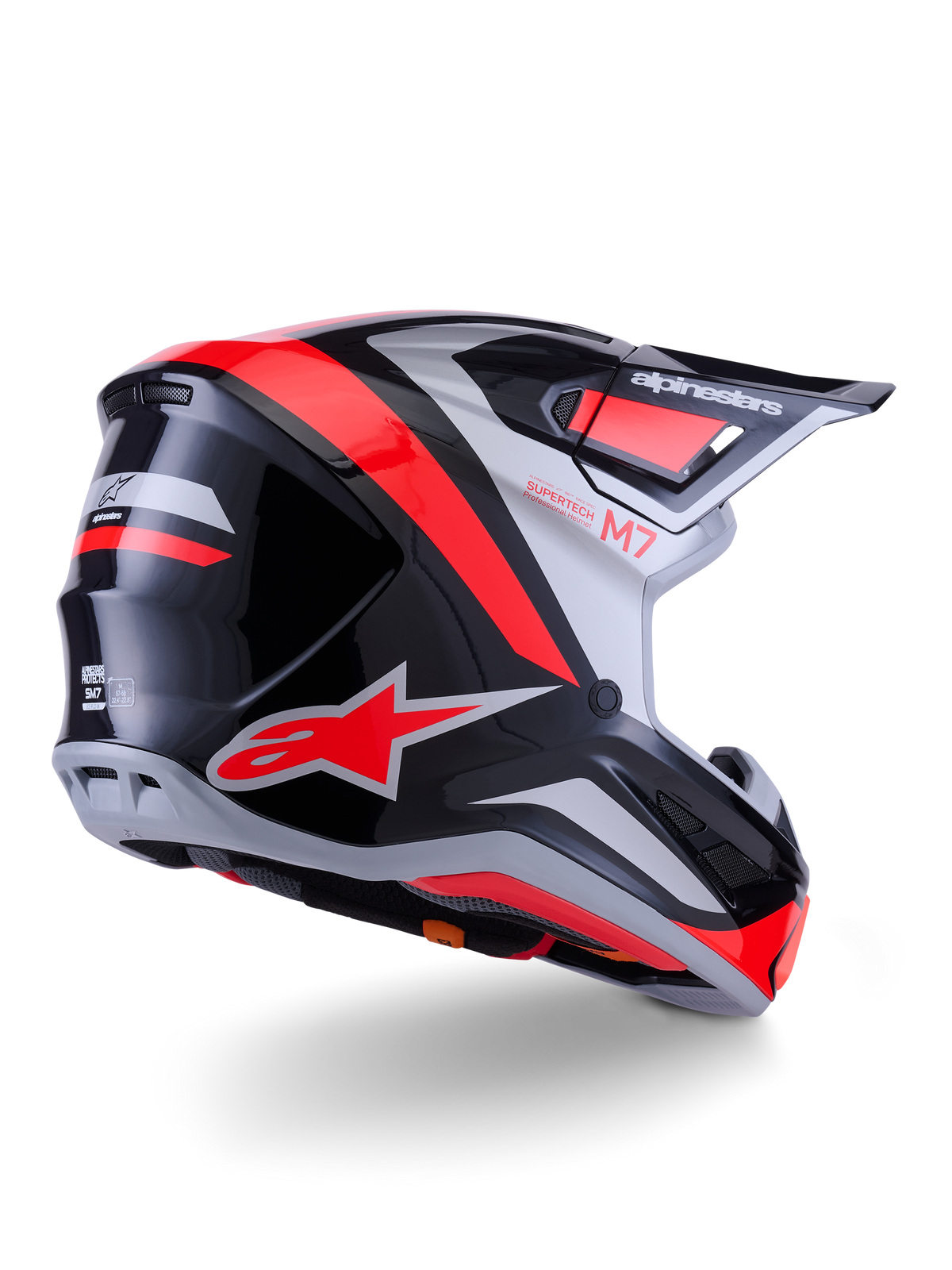 Alpinestars S-M7 Rise hjälm, motocrosshjälm, svart, silver och röd fluo glossy, vy trekvart bakifrån, med framträdande röd A-star-logotyp och silverdetaljer, aerodynamiskt skal med skärm, professionellt skydd för terrängkörning