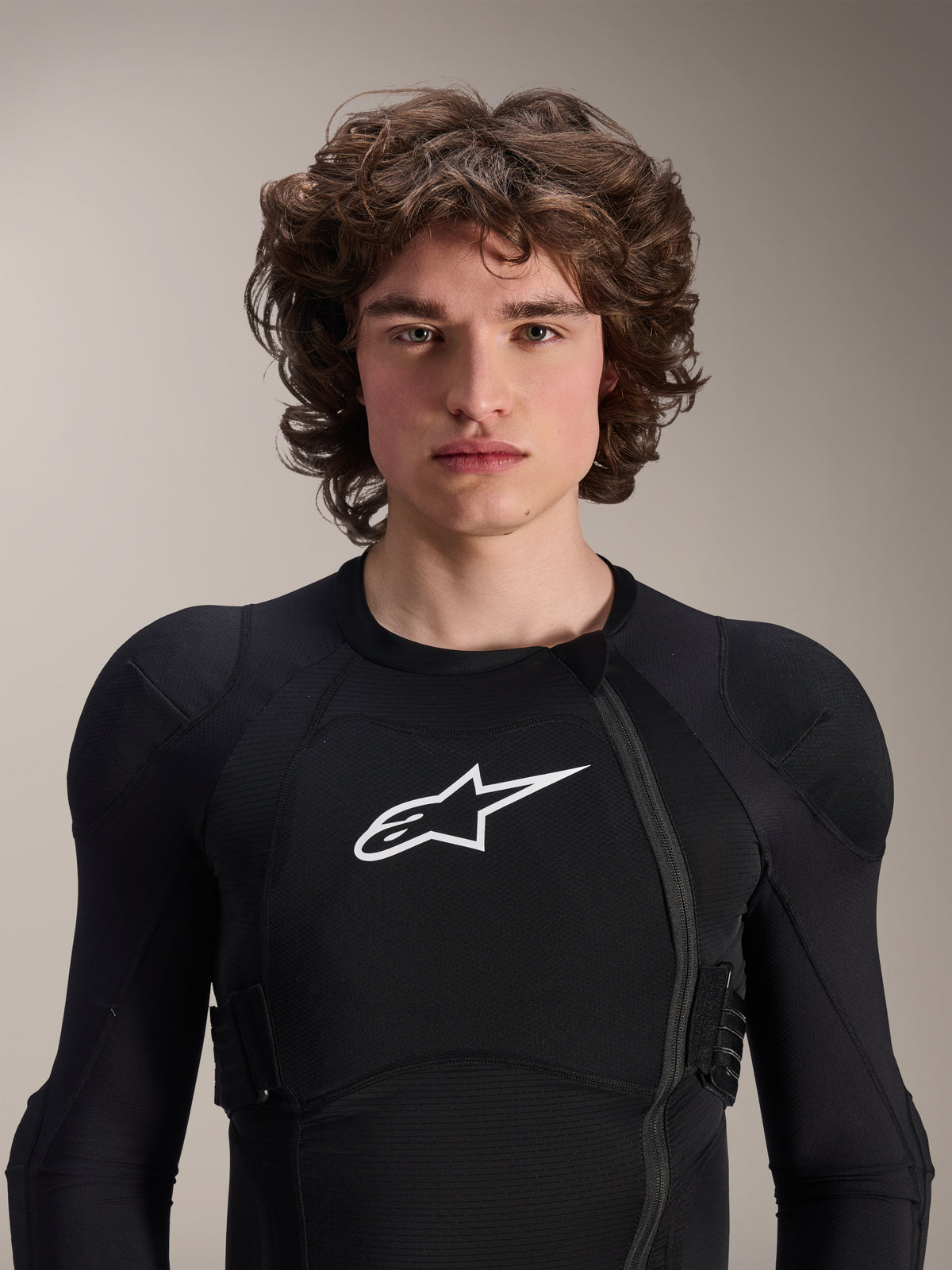 Male model wearing Alpinestars A-Impact Plasma Protection Jacket - Long Sleeve, Black with white Astars logo, featuring an offset front zipper and integrated padding, professional MTB protection gear