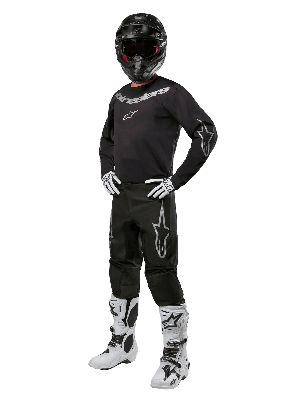 Alpinestars 2024 Fluid Graphite Gear Set, komplett motocrossutrustning, svart med grå och vita logotyper, med tröja och byxor som bärs tillsammans med matchande svart hjälm, vita och svarta handskar och stövlar, designad för skydd vid terrängkörning