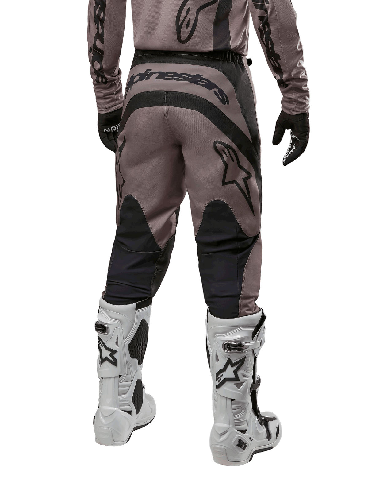 Alpinestars 2024 Fluid Lurv byxor, motocrossbyxor, Mud Black, vy bakifrån som visar stor svart Alpinestars-logotyp på sätet och svarta vadpaneler, bärs med vita och svarta motocross-stövlar och matchande tröja.