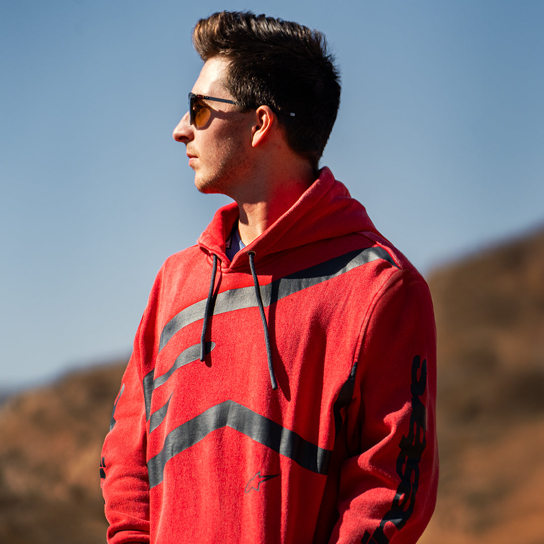 Alpinestars Unbound Hoodie, röd plaggfärgad fleece, med en extra stor svart logotyp på bröstet och Alpinestars-text på ärmarna, huva med dragsko, avslappnad motorsportinspirerad streetwear