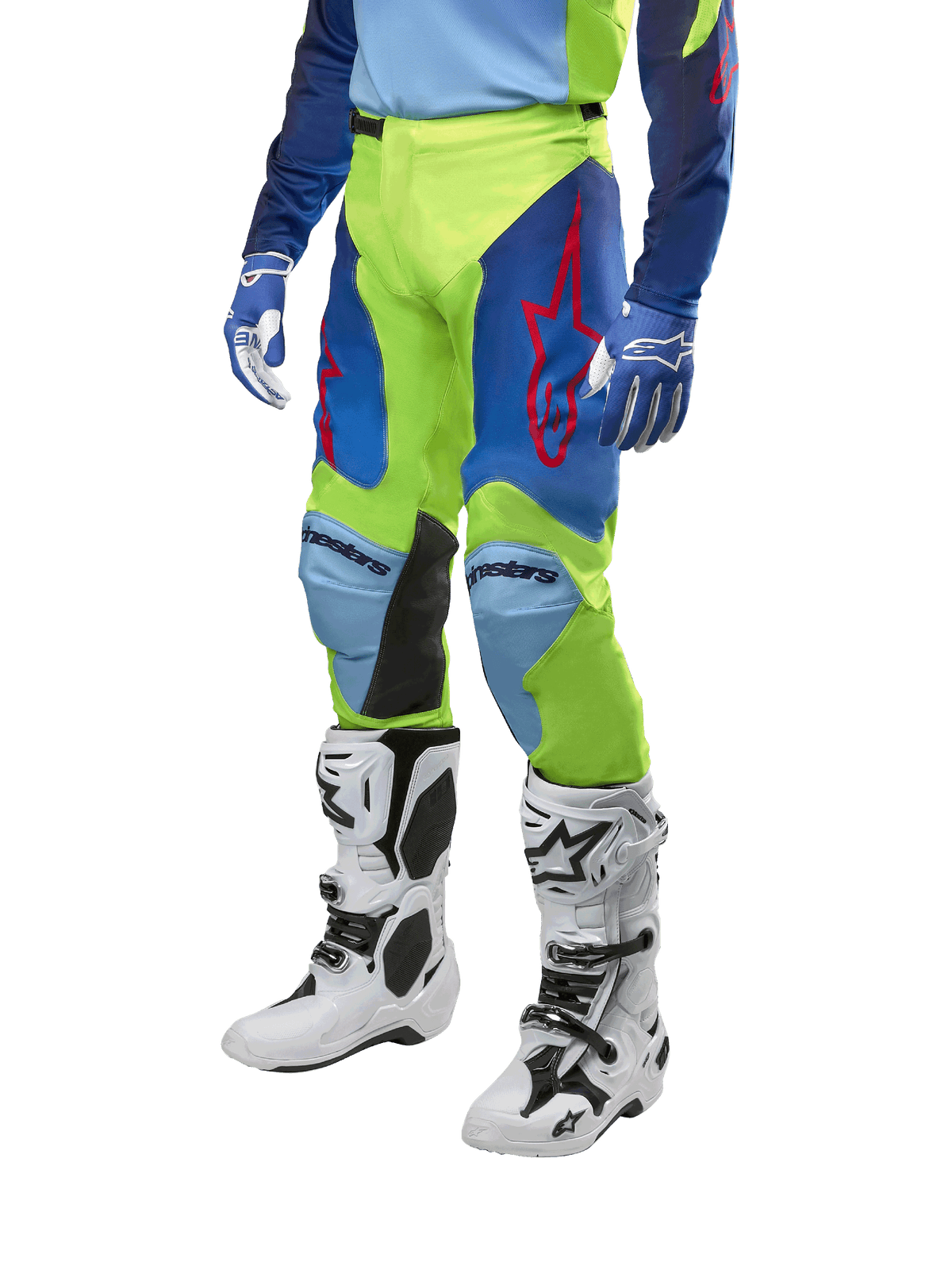 Alpinestars 2024 Racer Hoen-byxor, motocrossbyxor, neongula och mörkblå, med röda stjärnlogotyper och svarta paneler på insidan av knäna, bärs med matchande tröja och vita motocross-stövlar, prestandautrustning för terrängkörning