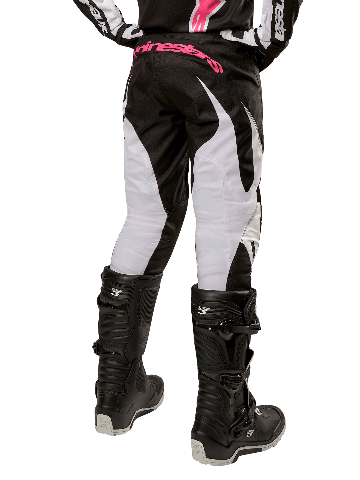 Alpinestars Stella Fluid-byxor för damer 2024, motocrossbyxor, svarta och vita, vy bakifrån med vita benpaneler och rosa logotyp på midjan, bärs med svarta Tech 3-stövlar, slitstark utrustning för terrängkörning
