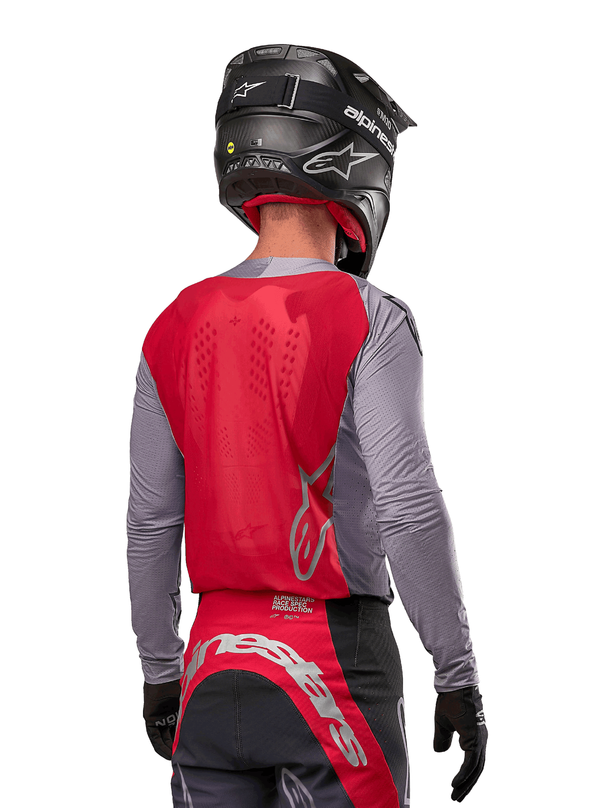 Motocrossförare sedd bakifrån i Alpinestars 2024 Supertech Dade-tröja i Iron Red Berry och grått, med en ventilerande ryggpanel i mesh och logotyper i silver, matchad med svart hjälm och racingbyxor för professionell terrängkörning