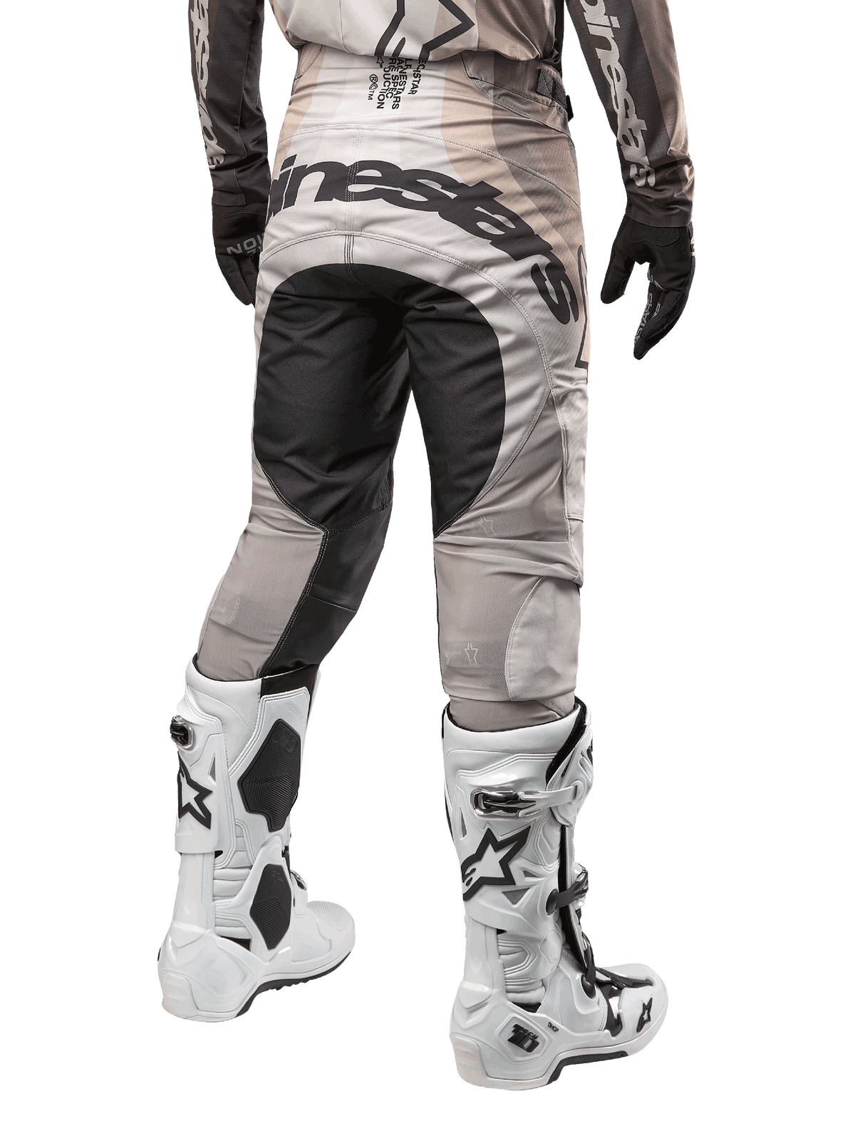 Alpinestars 2024 Techstar Pneuma Pants, Motocross Pants, Dark Sand and Iron Dust Gray, rear view from the waist down, bold black Alpinestars branding on the seat, worn with white and black motocross boots and black gloves, durable race-fit design for off-road competition