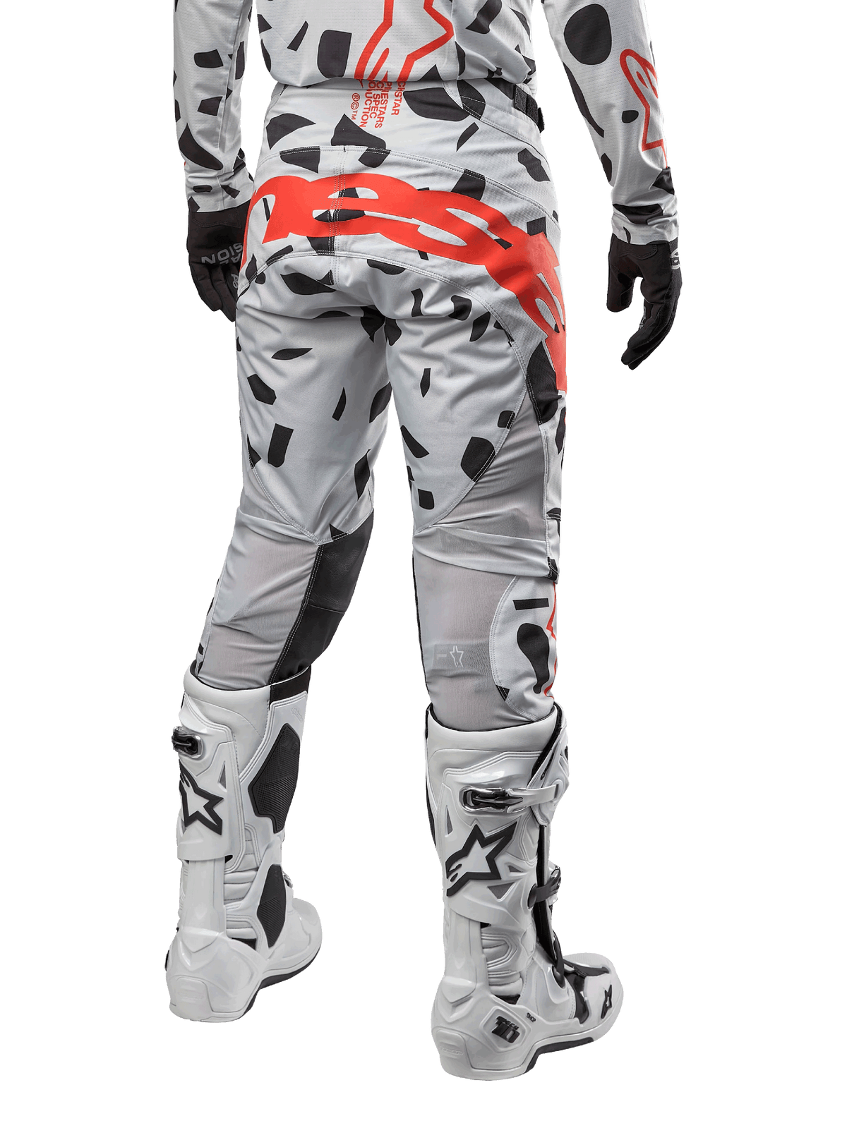 Alpinestars 2024 Techstar Rantera-byxor, motocrossbyxor, Haze Gray Camo, med svarta kamouflagemönster och en stor röd Alpinestars-logotyp på sätet, sedda bakifrån tillsammans med vita stövlar och matchande racingutrustning