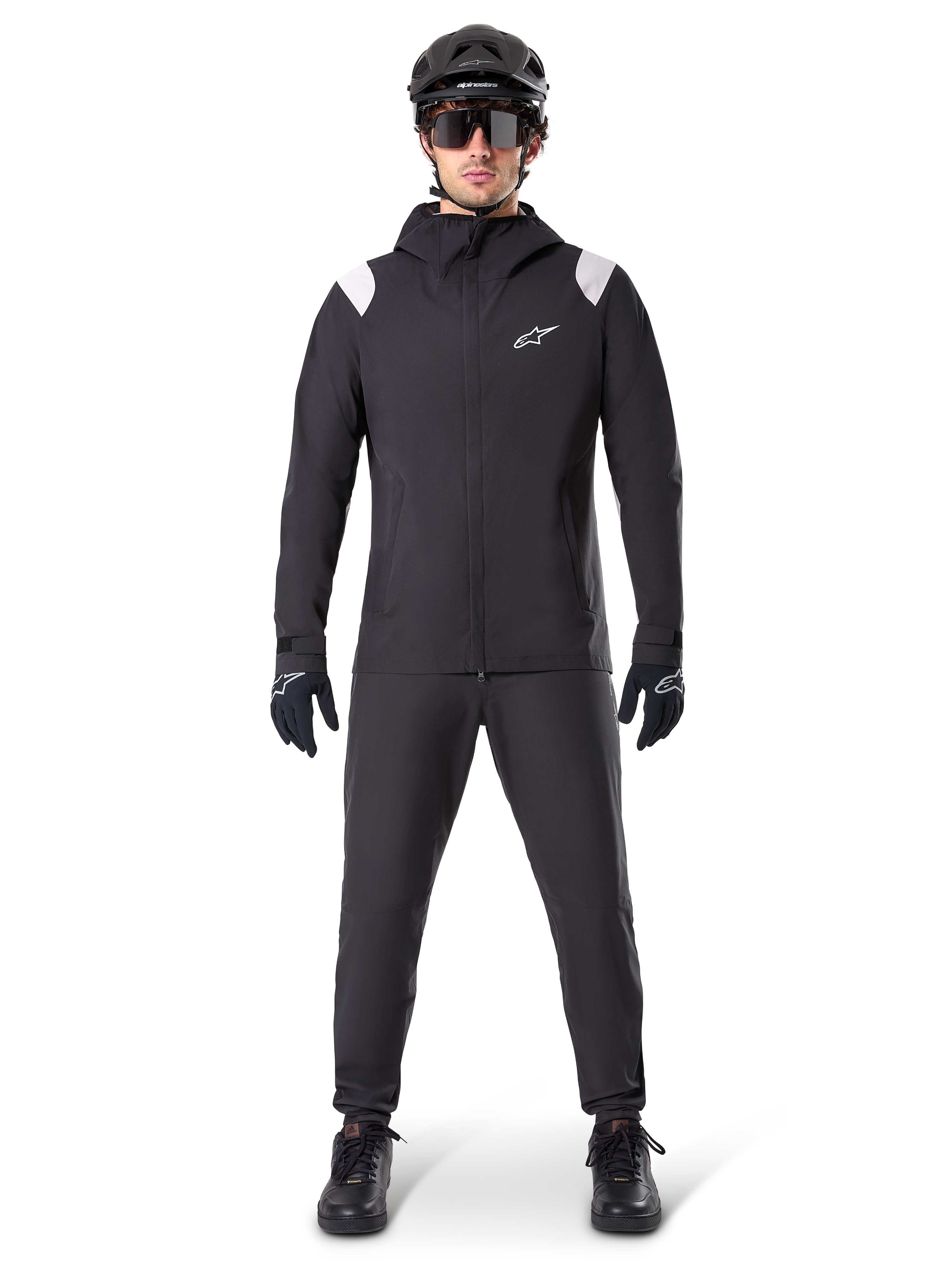 Alpinestars A-Dura regnjacka, regnjacka för mountainbike, svart med vita axeldetaljer och vit logotyp på bröstet, bärs med svarta byxor, svart hjälm, solglasögon och handskar, matchande mountainbike-utrustning för vått väder
