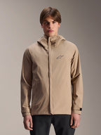 Alpinestars A-Dura Rain Jacket, Light Brown hooded mountain bike rain jacket, worn by a model, featuring a small chest logo, adjustable cuff straps, and concealed front zipper, waterproof cycling gear