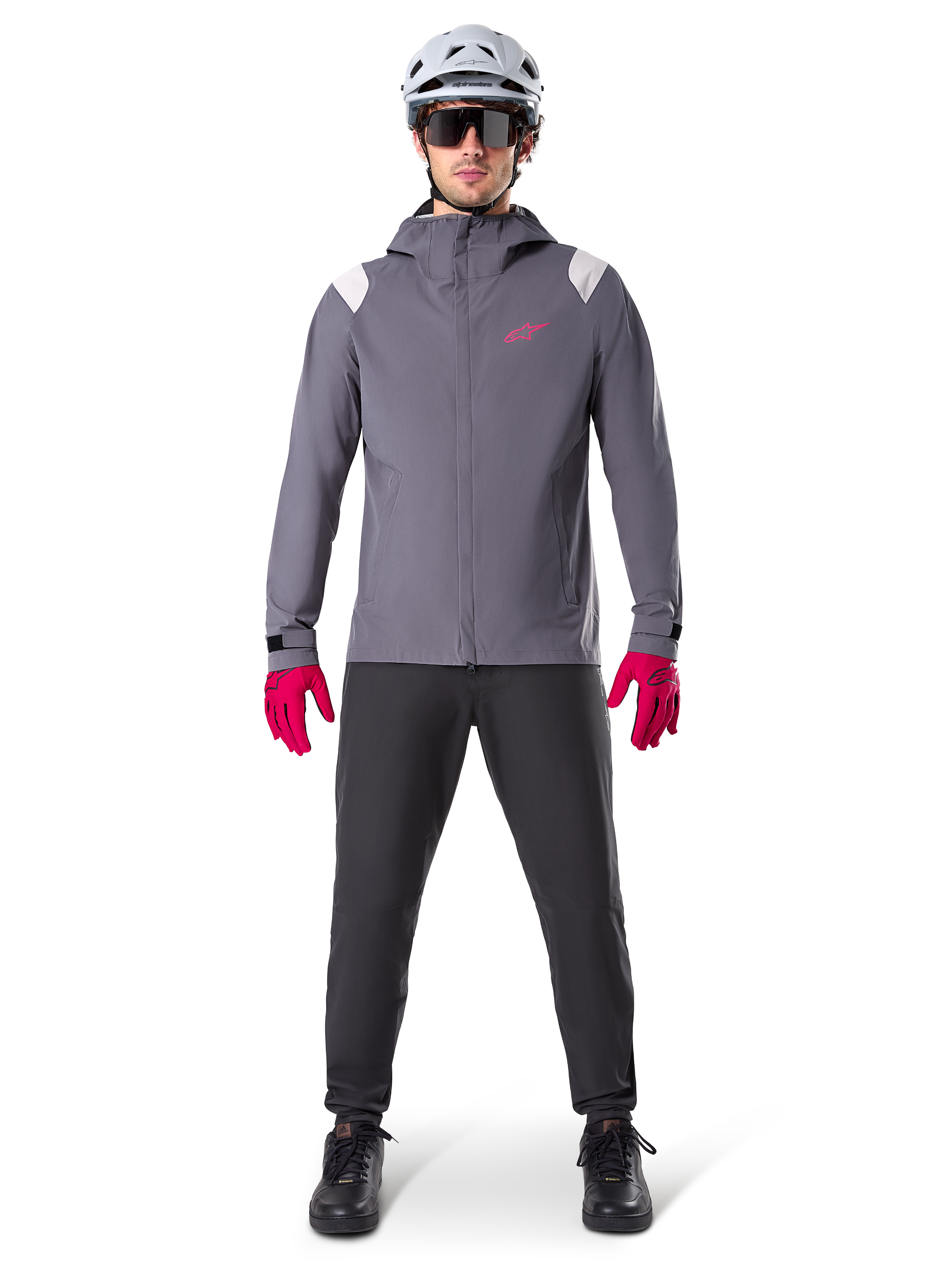 Alpinestars A-Dura regnjacka, mountainbikejacka, Dark Titanium-grå med rosa logotyp, bärs med grå MTB-hjälm och klarrosa handskar, skyddande 2,5-lagers membrankonstruktion för cykling i vått väder