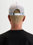Alpinestars Cali 2.0 keps, trucker keps för vardagsbruk, khaki och vit, vy bakifrån som visar den justerbara snapback-stängningen och det ventilerande vita meshtyget, bärs av en modell