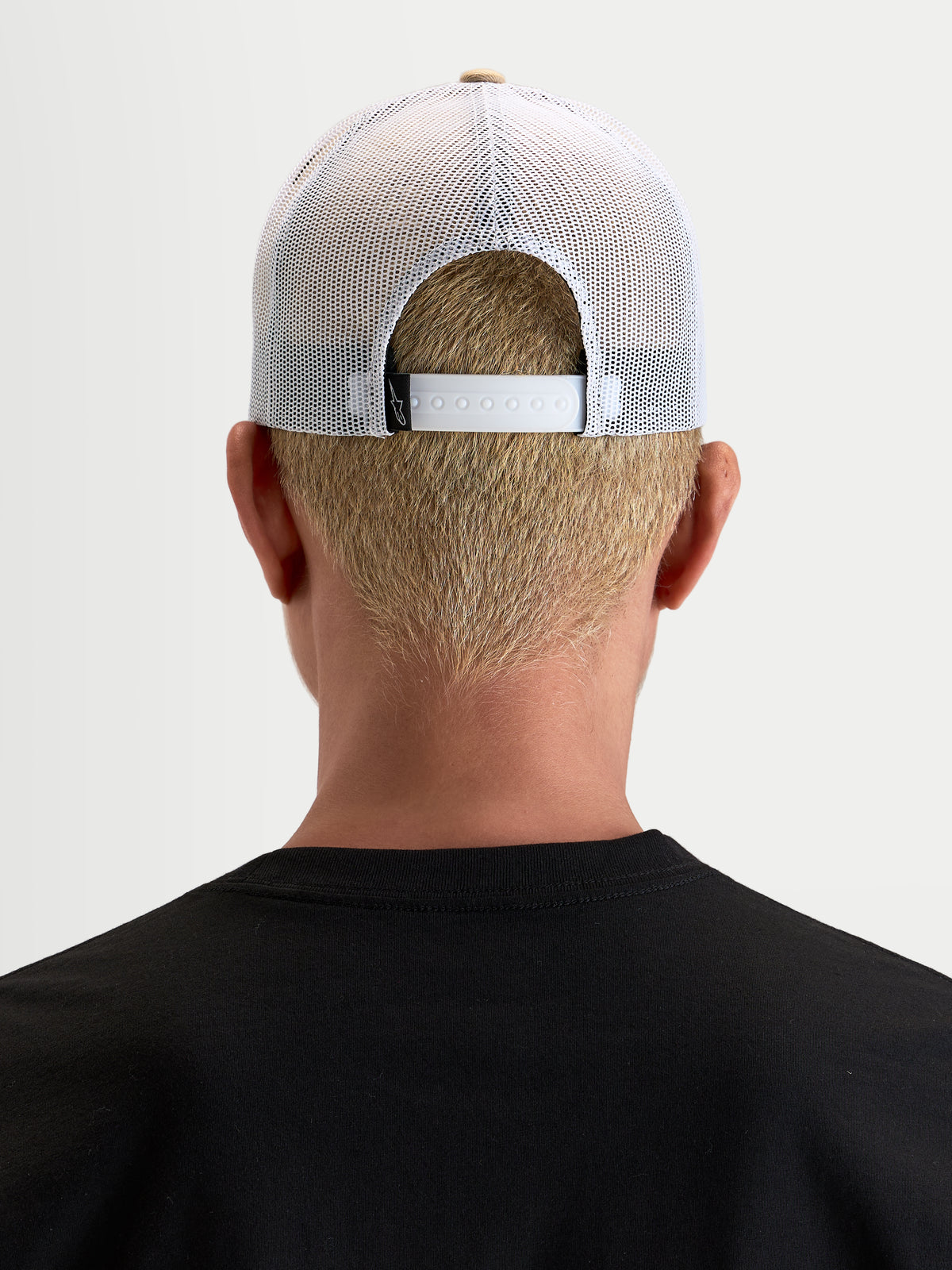 Alpinestars Cali 2.0 keps, trucker keps för vardagsbruk, khaki och vit, vy bakifrån som visar den justerbara snapback-stängningen och det ventilerande vita meshtyget, bärs av en modell
