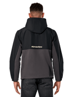 Alpinestars Juncture Hybrid-jacka, vy bakifrån, svart och gunmetal, avslappnad sportswear-anorak med konstruktion i blandade material, ripstop upptill och canvasfleece nedtill, Alpinestars-logotyp på ryggen, bärs med mörka byxor