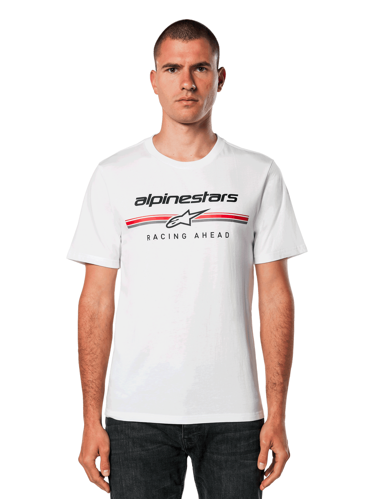 Alpinestars Betteryet CSF Tee, vit kortärmad t-shirt, med svart Alpinestars-logotyp samt röda och grå ränder med ”Racing Ahead”-grafik, bärs av en man i mörka jeans, avslappnad motorsport-streetwear