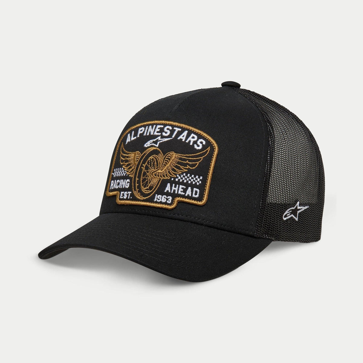 Alpinestars Heritage Patch Trucker-keps, svart, strukturerad krona med böjd skärm, stort broderat heritage-märke framtill med vingat hjul och 'Racing Ahead Est. 1963', svarta meshpaneler baktill med stjärnlogotyp på sidan, huvudbonad för en avslappnad motorsport-livsstil