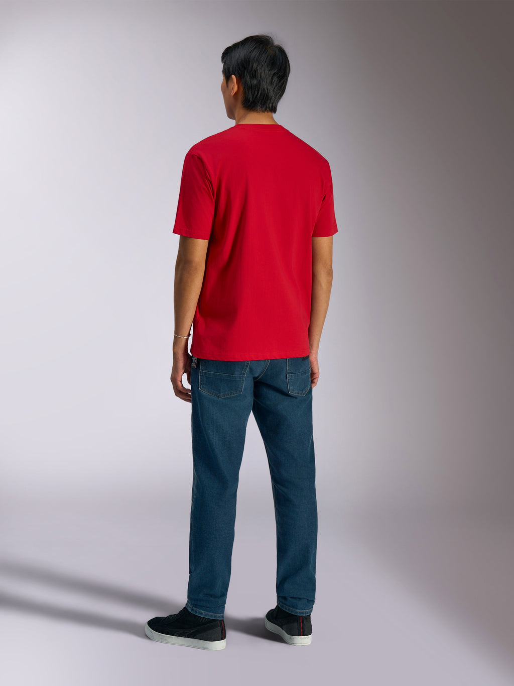 Alpinestars Ageless Shadow CSF Tee, kortärmad t-shirt, röd, baksida buren av modell med blå jeans och svarta sneakers, vardaglig motorsport-streetwear